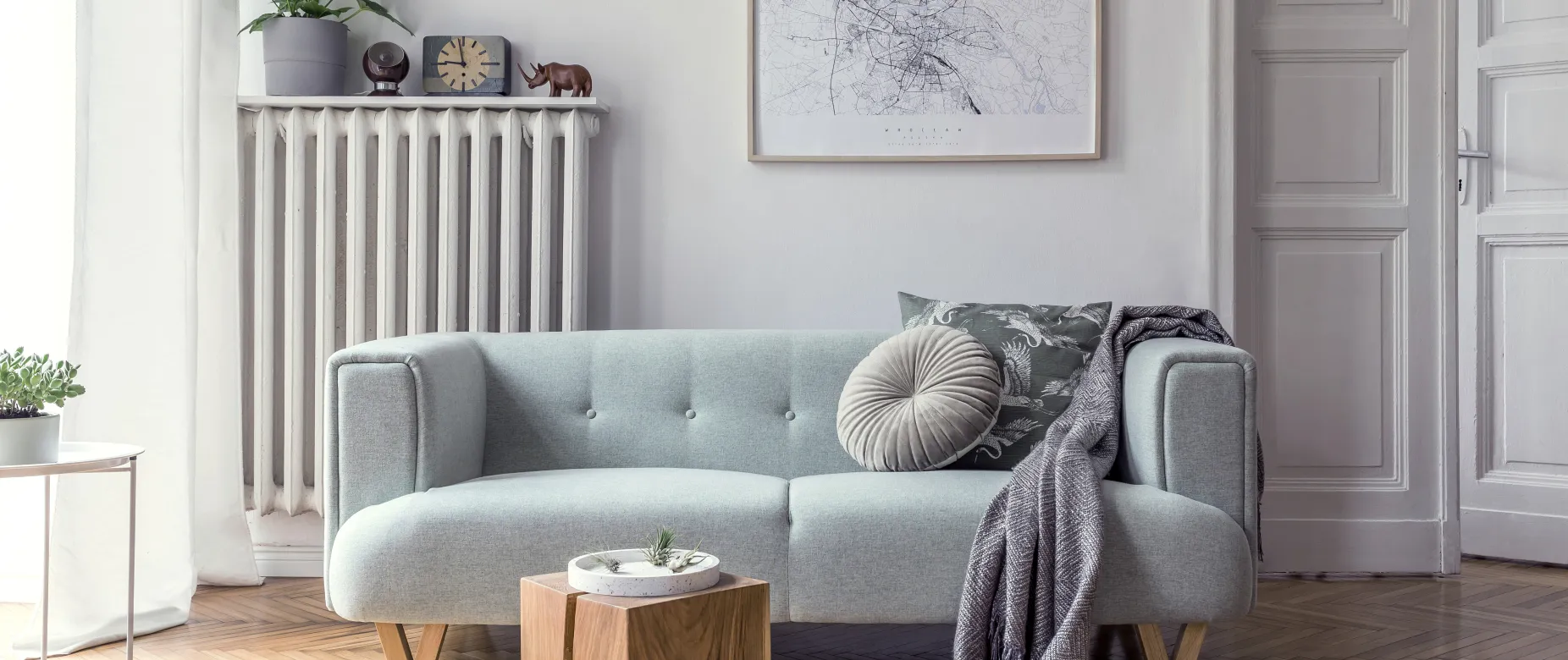 Modernes Wohnzimmer mit hellgrauer Couch und verschiedenen Dekorationen